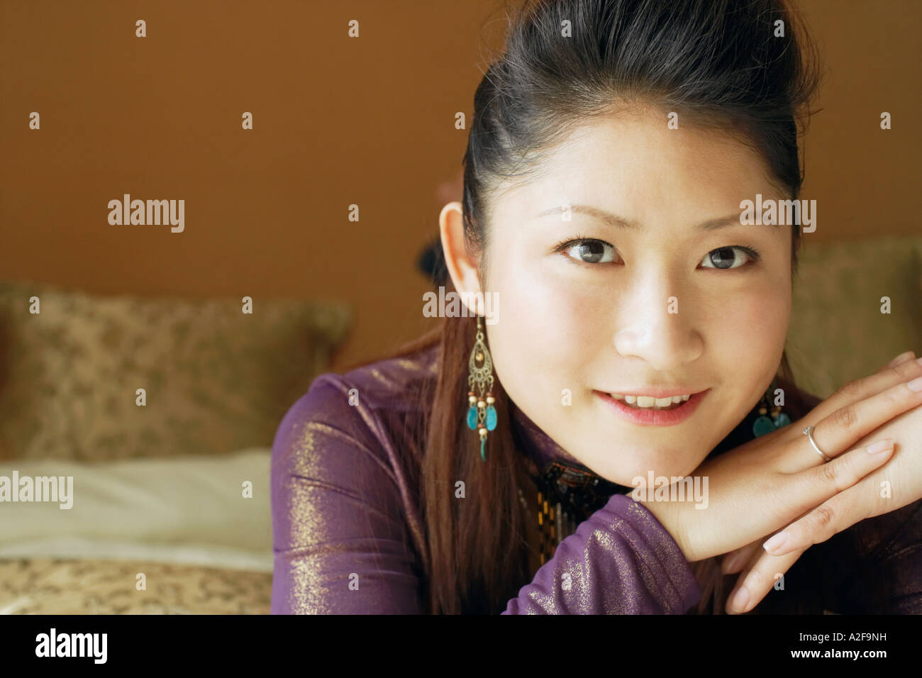 Portrait of a young woman with her hand on her chin smiling Stock Photo ...