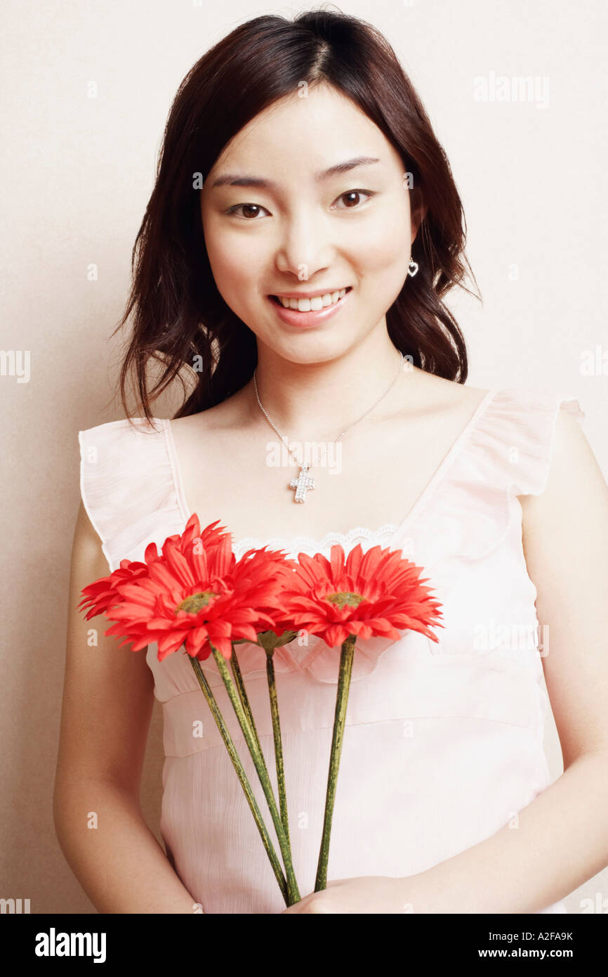 Portrait of a young woman holding flowers Stock Photo - Alamy