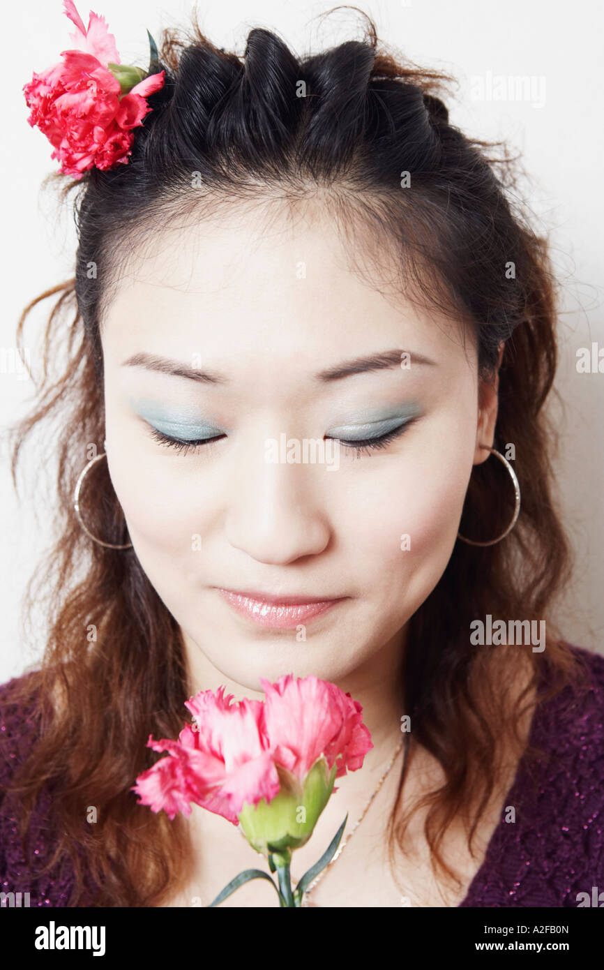Close-up of a young woman smelling a flower Stock Photo - Alamy