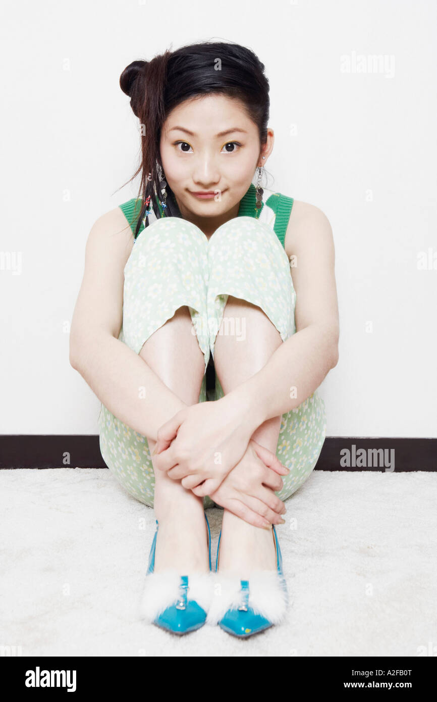 Portrait of a teenage girl hugging her knees Stock Photo - Alamy