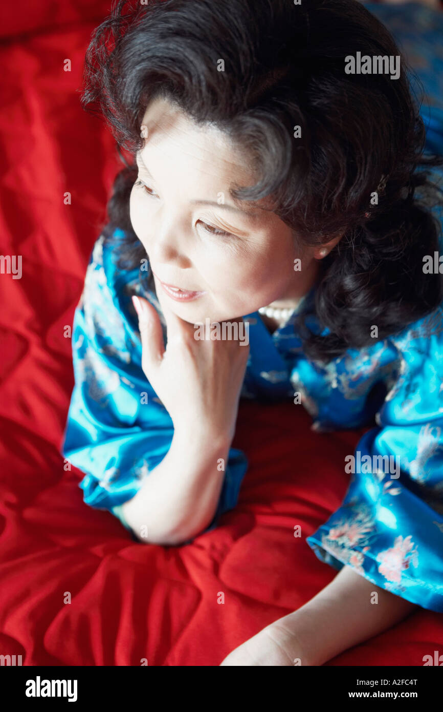 High angle view of a mature woman lying on the bed smiling Stock Photo ...