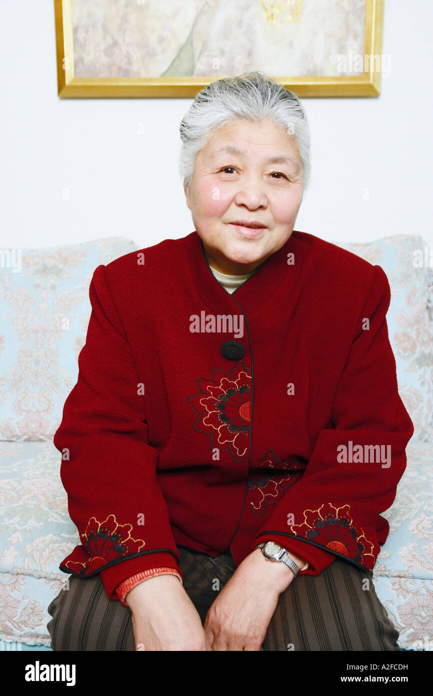 Portrait of a senior woman sitting on a couch Stock Photo - Alamy