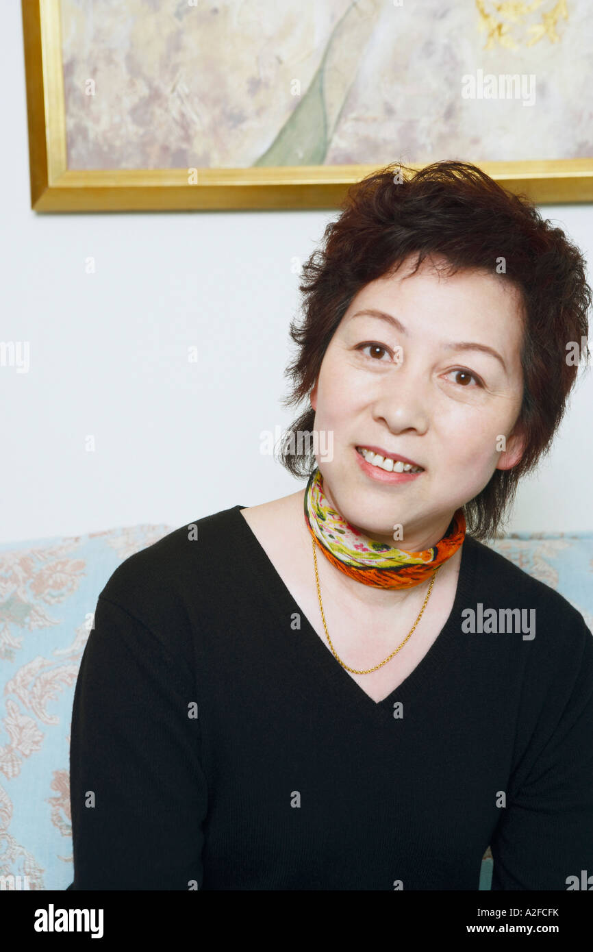 Portrait of a mature woman sitting on a couch Stock Photo - Alamy