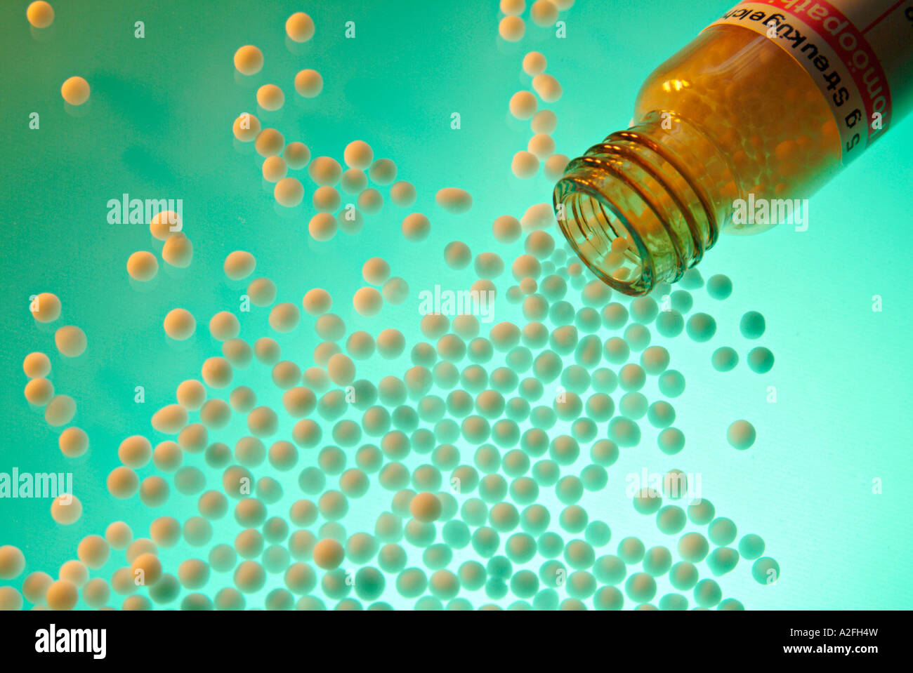 Homeopathic remedy, globules rolling out from a medicin bottle Stock Photo