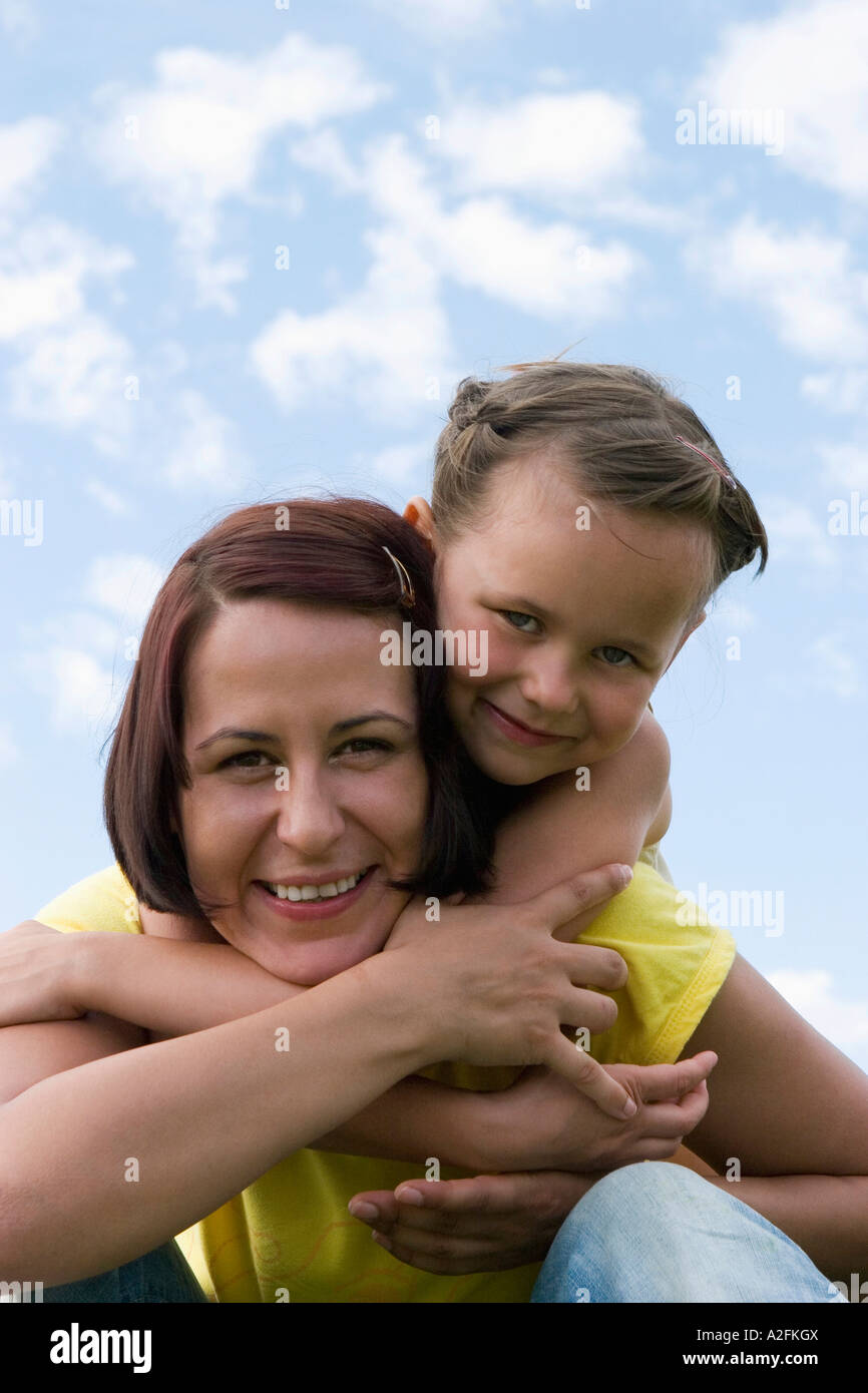 Mother carrying daughter on back, portrait Stock Photo - Alamy