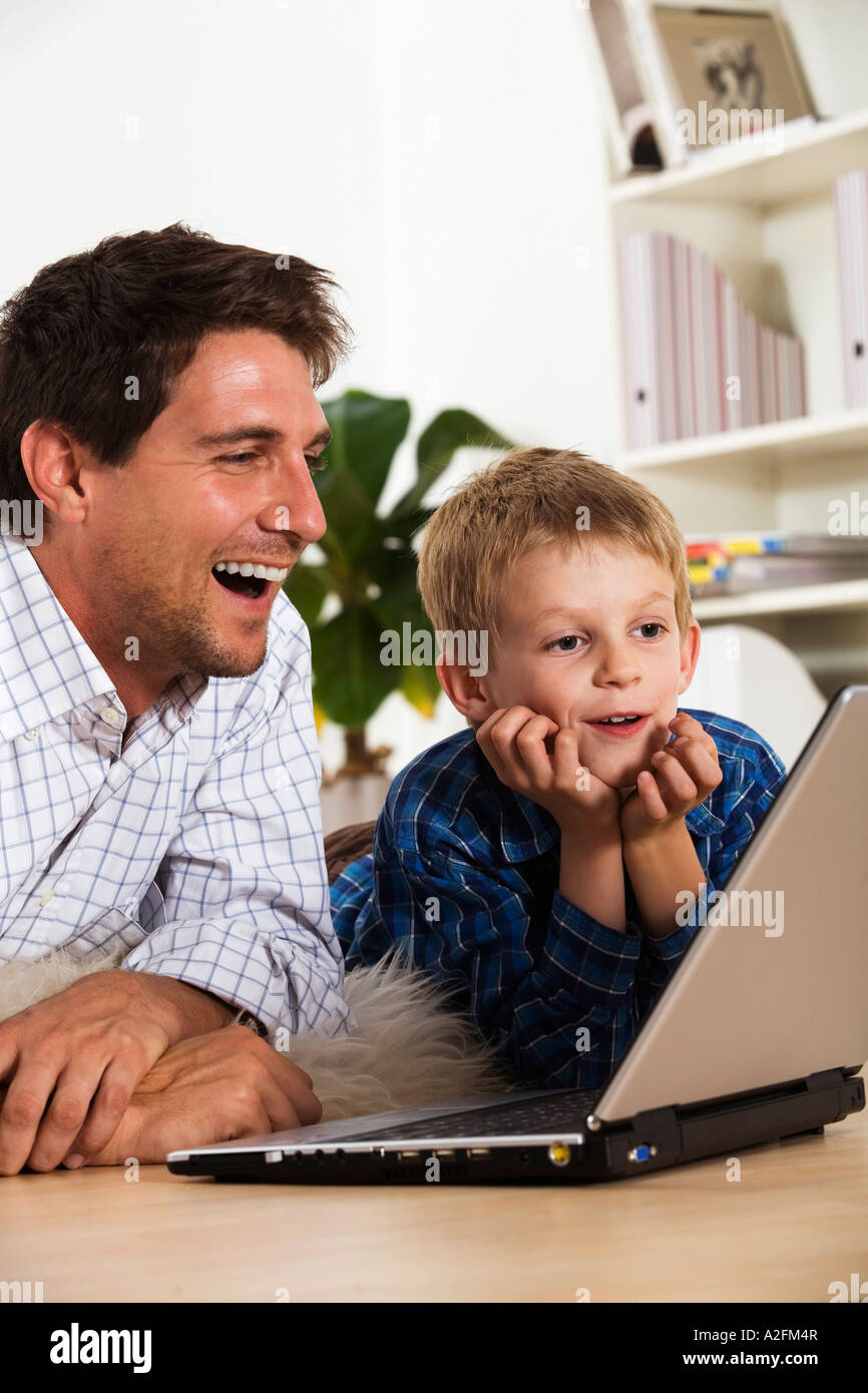 Father and son (6-7) using laptop Stock Photo