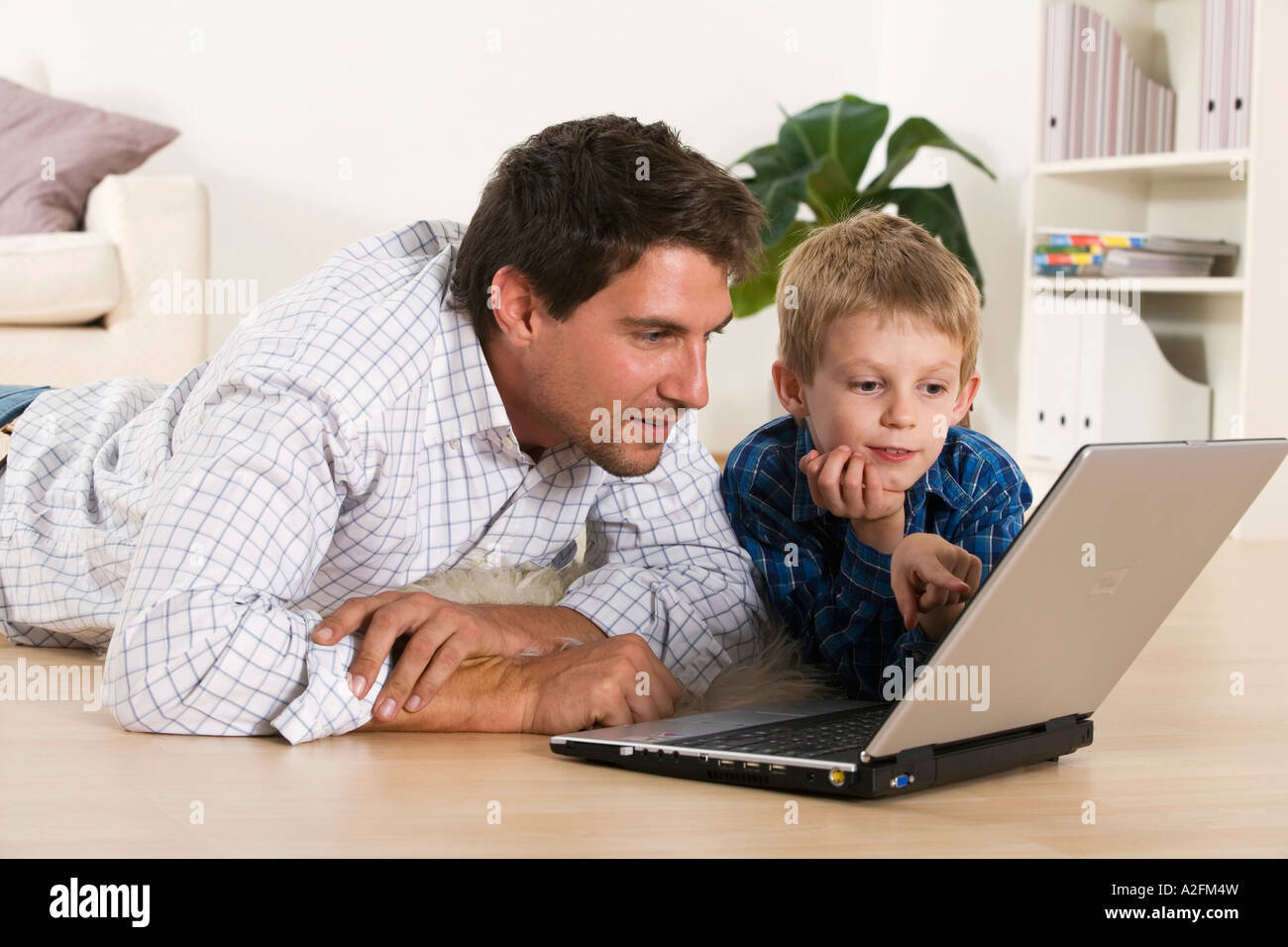 Father and son (6-7) using laptop, close-up Stock Photo