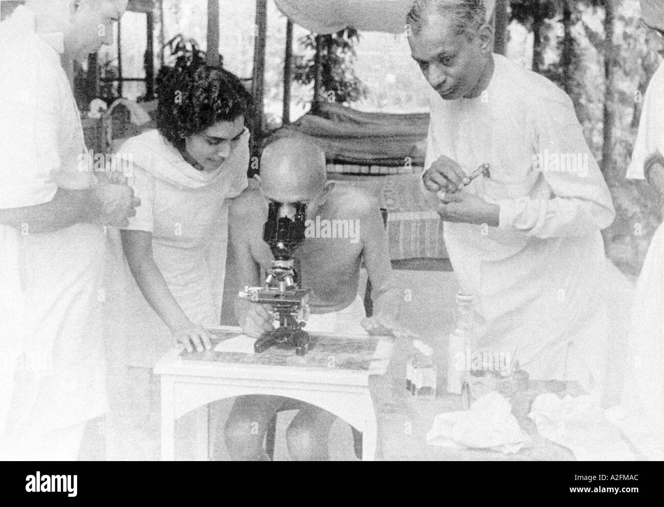 Mahatma Gandhi curious observing showing keen interest in seeing hookworm ova cells through microscope at Juhu Beach mumbai 1944 Stock Photo