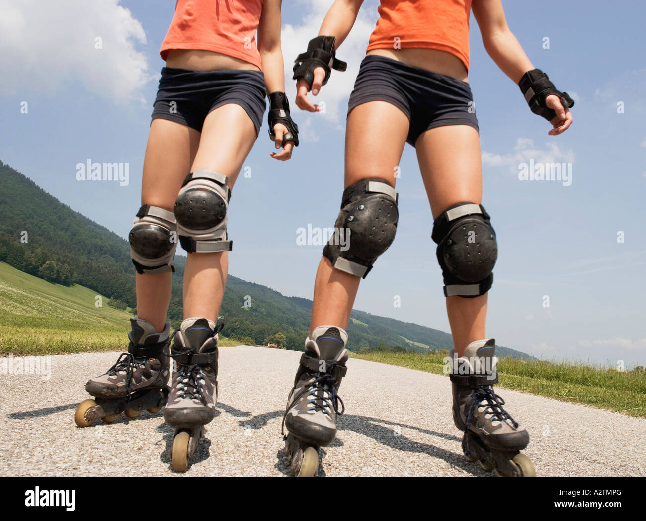 Two teenage girls (13-15) inline skating, low section Stock Photo - Alamy