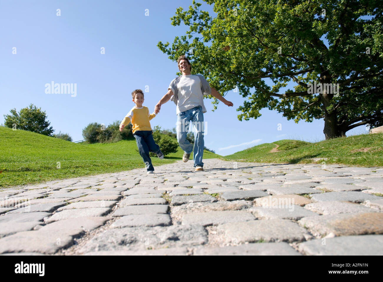 Father and son (4-7) running in park Stock Photo