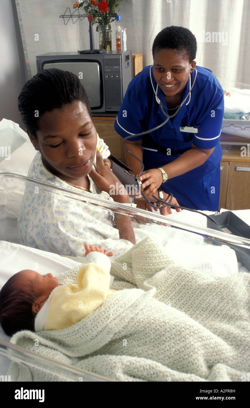 hospital midwife taking blood pressure of mother who has just given birth to her baby Stock Photo