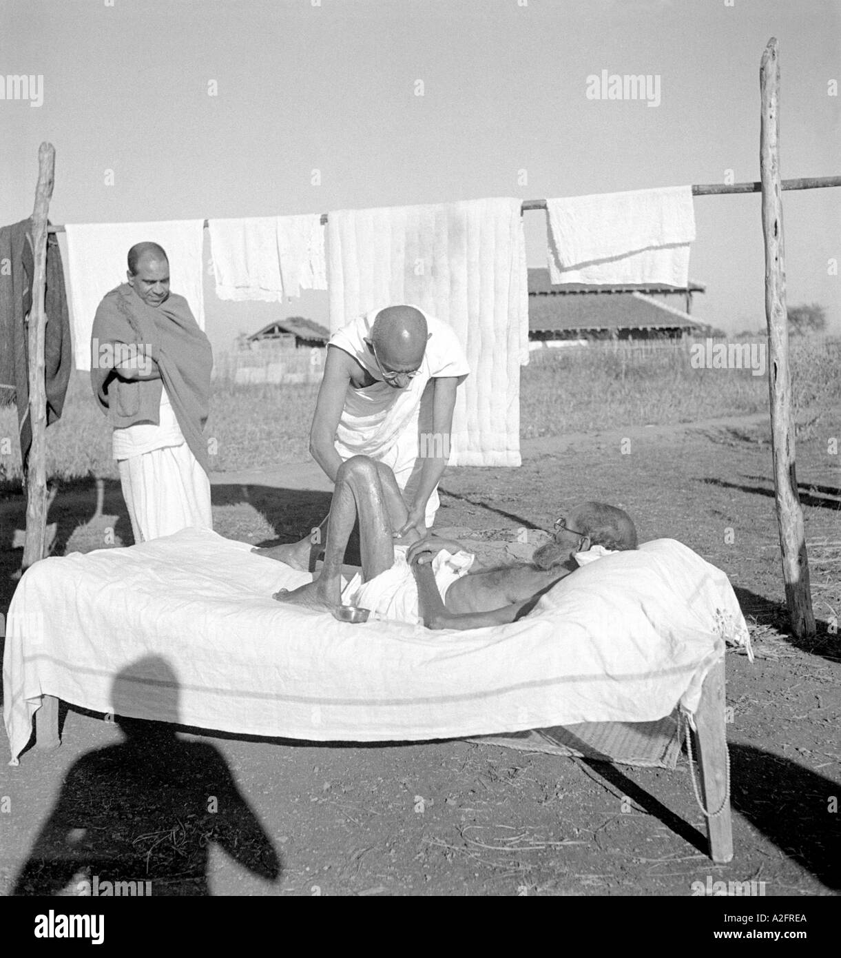 Mahatma Gandhi caring giving massage to a sick diseased leper patient at Sevagram Ashram Wardha Maharashtra India 1940 Stock Photo
