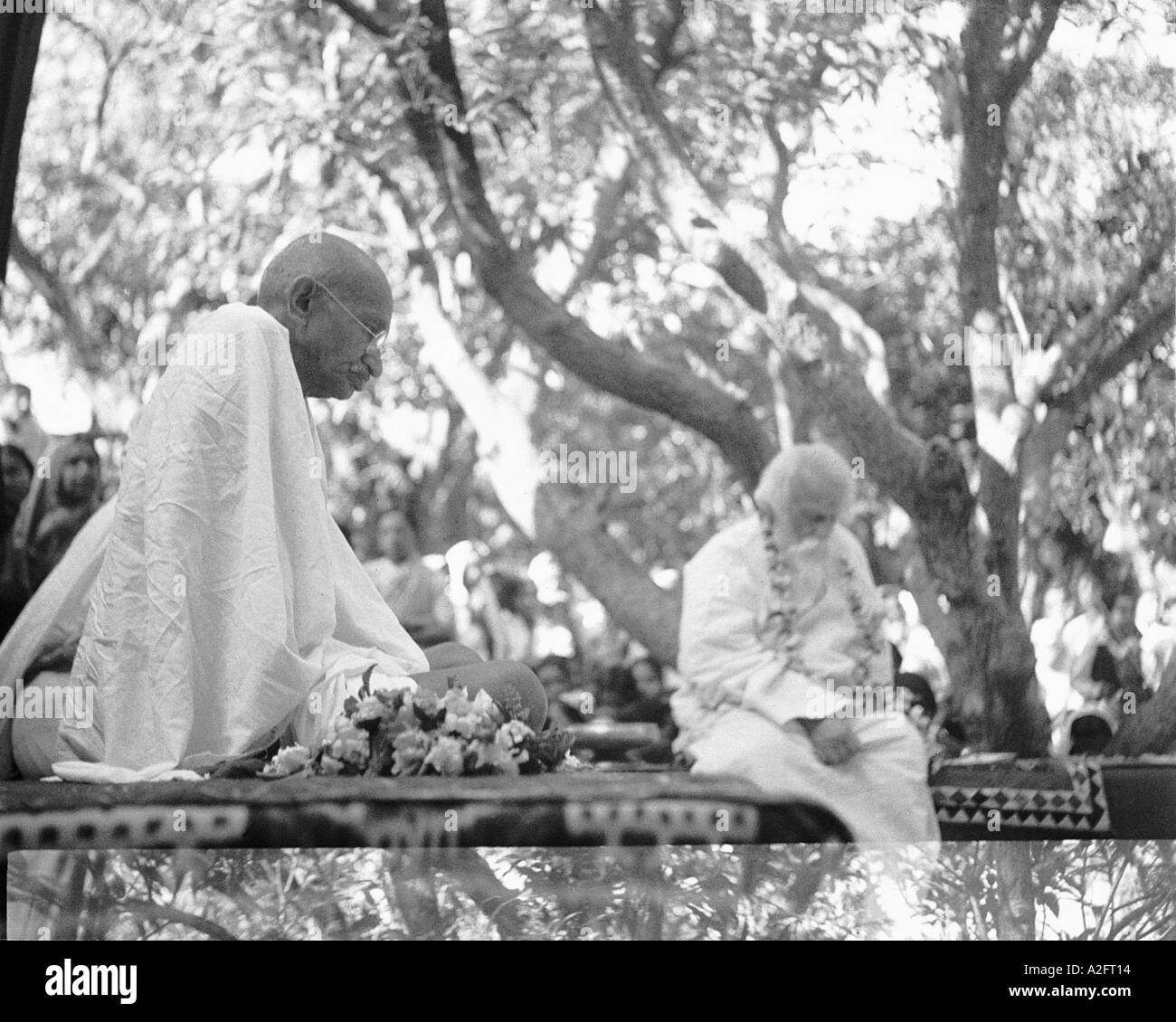 Mahatma Gandhi sitting under the shade of a tree with poet Rabindranath Tagore India old vintage 1900s picture Stock Photo