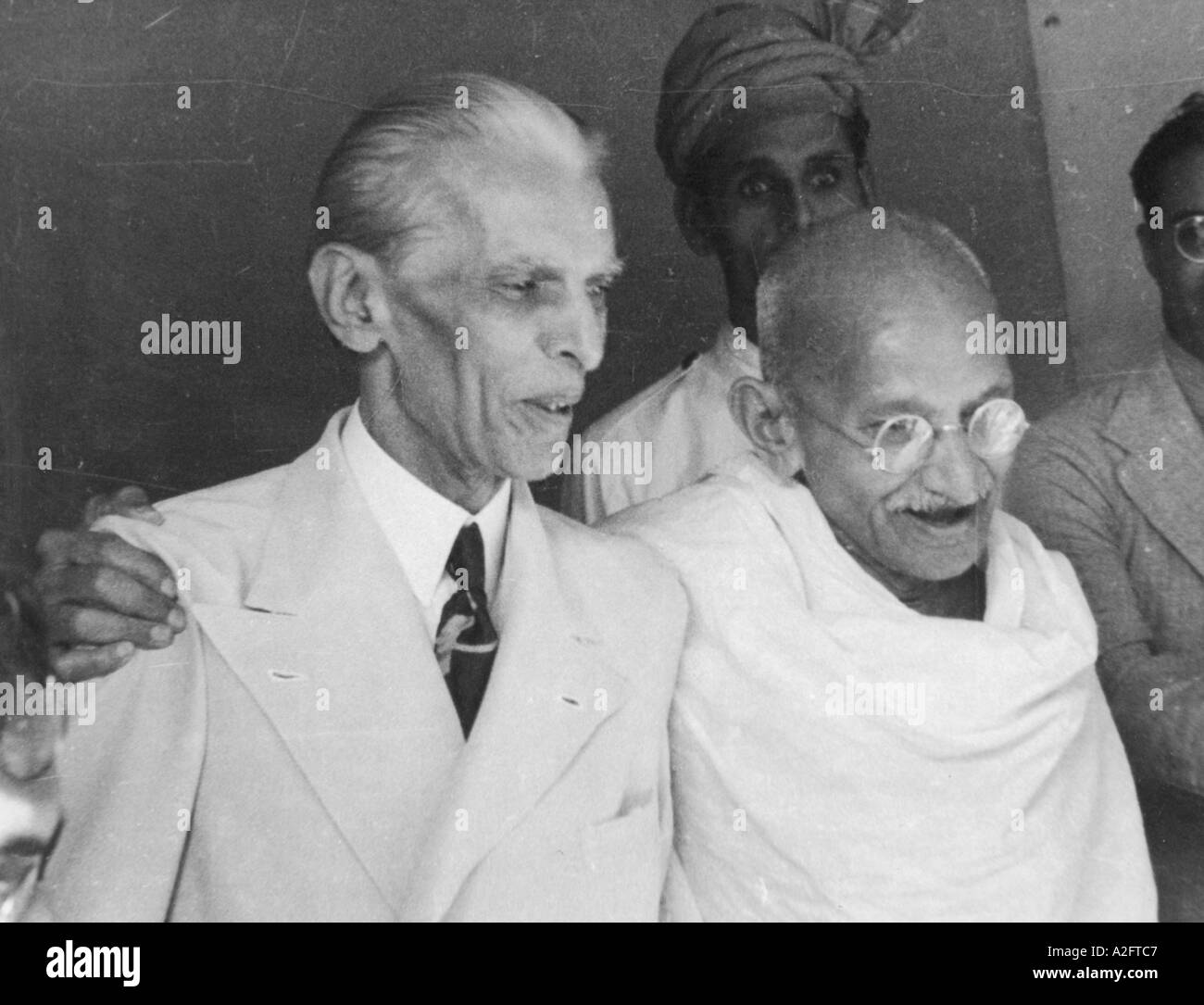 mkg 33182 - Mahatma Gandhi talking with arms around Muhammed Ali Jinnah in suit tie standing Mumbai Bombay India - 9 September 1944 Stock Photo