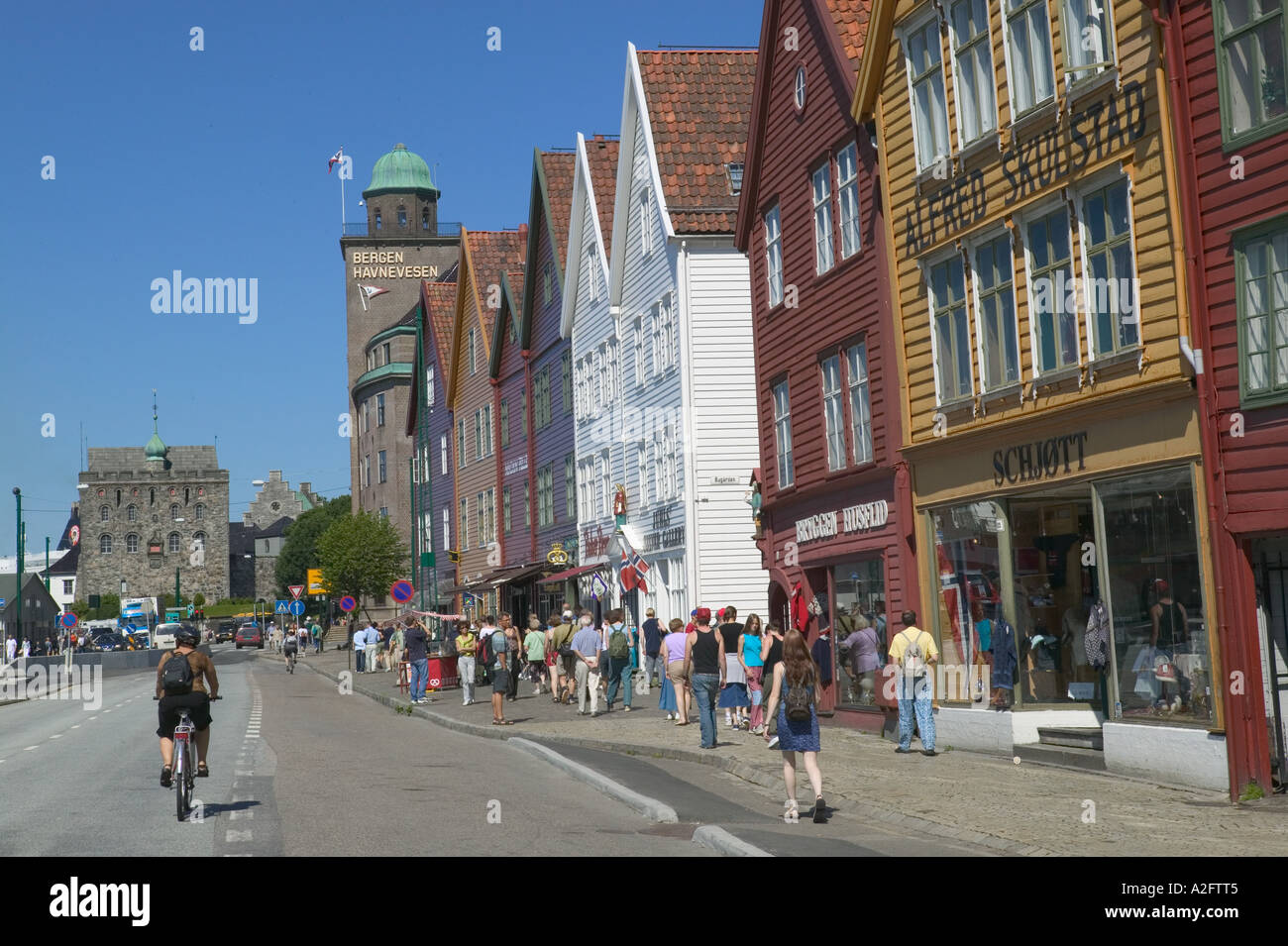 Shoppers stroll in Bryggen, UNESCO World Heritage Site, ancient wood buildings along the waterfront Stock Photo