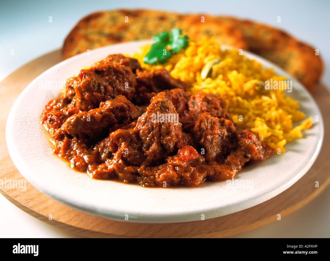 Individual portion lamb rogan josh curry saffron rice naan hires stock
