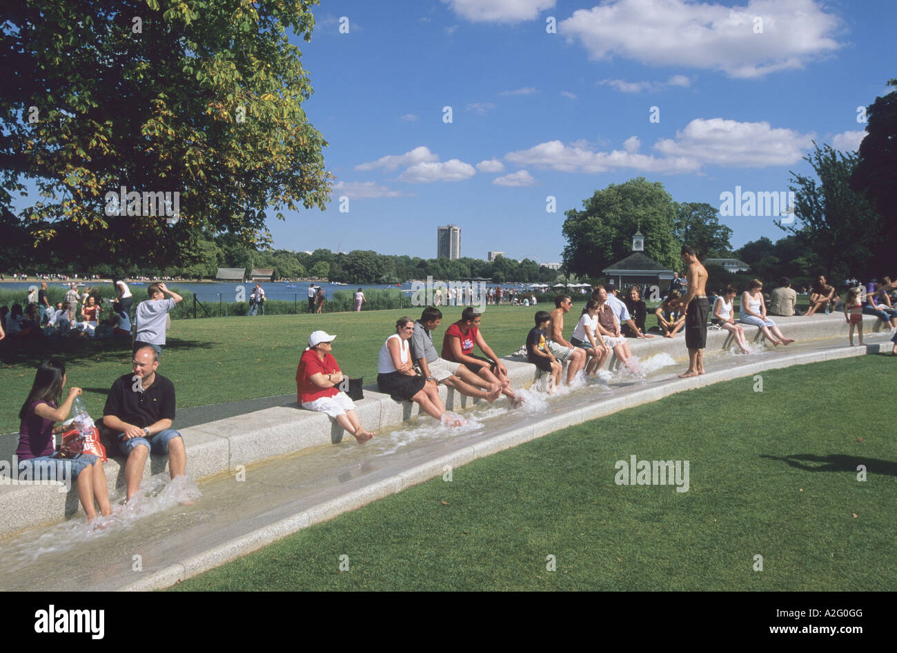 people sitting with their feet in the water of the Princess Diana Fountain,  Hyde park, London Stock Photo - Alamy