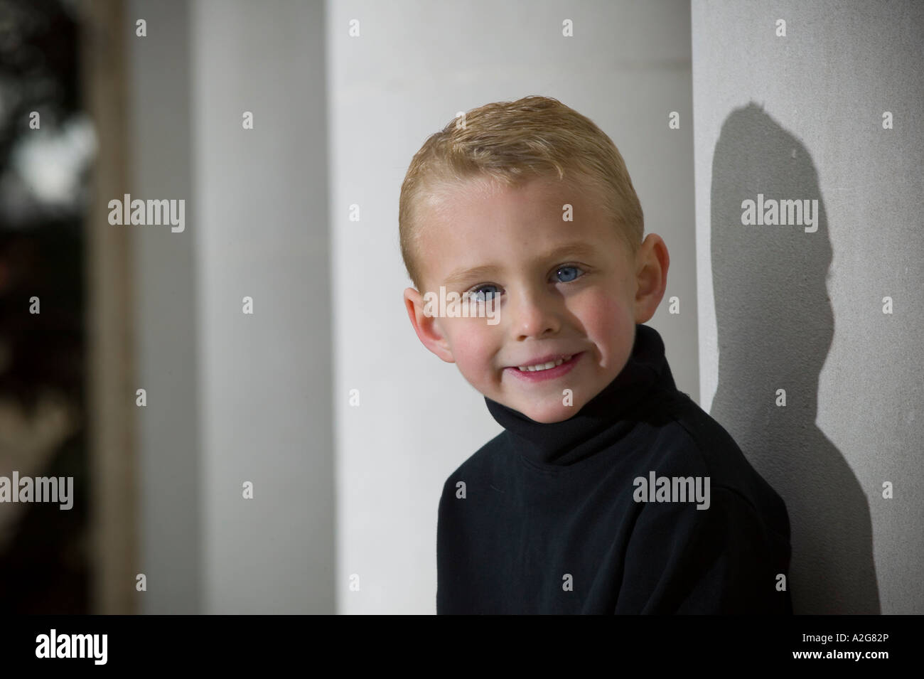 Portrait of young boy in black turtleneck sweater looking at camera and