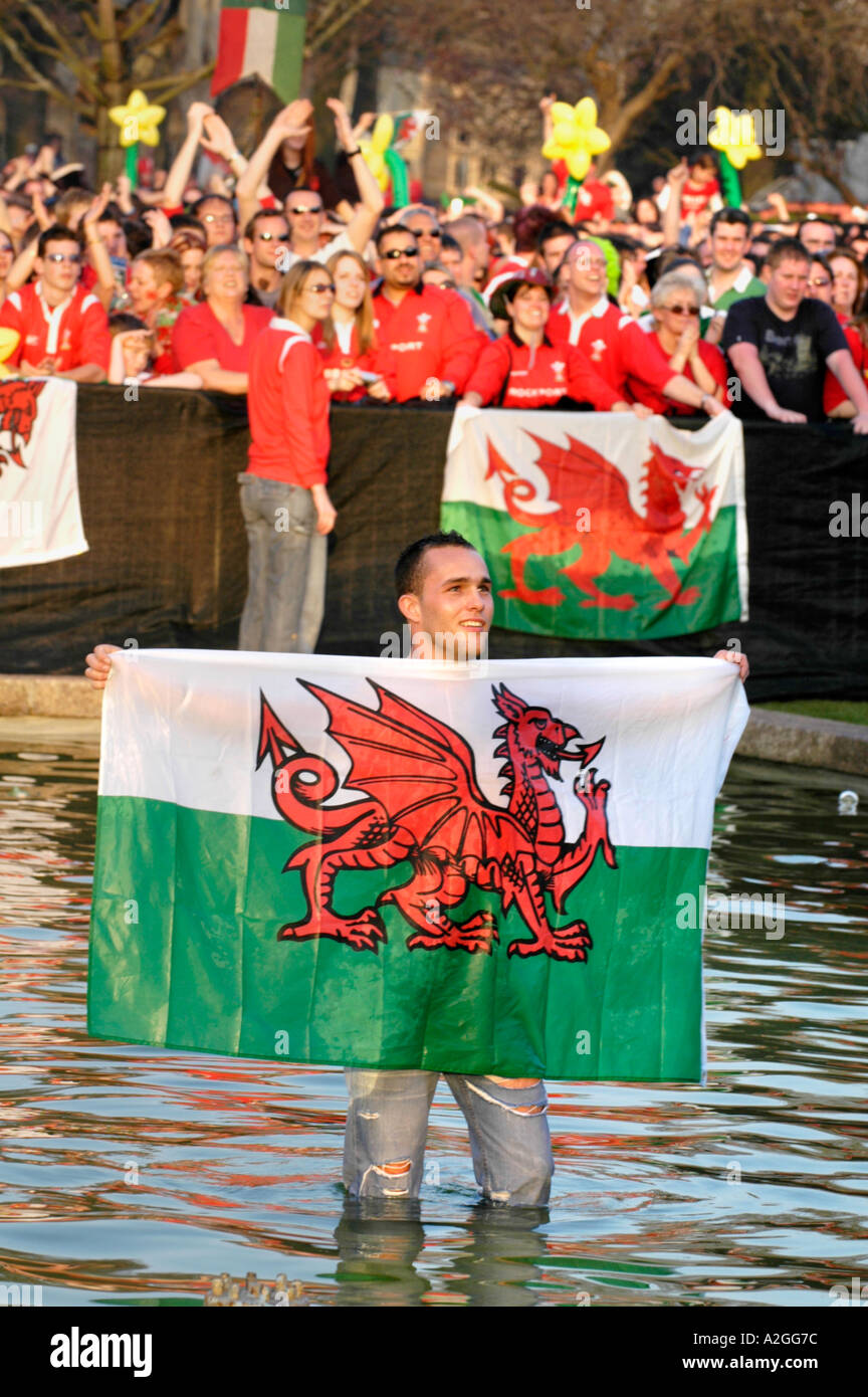 Wales rugby fans with Welsh red dragon flags celebrate after an