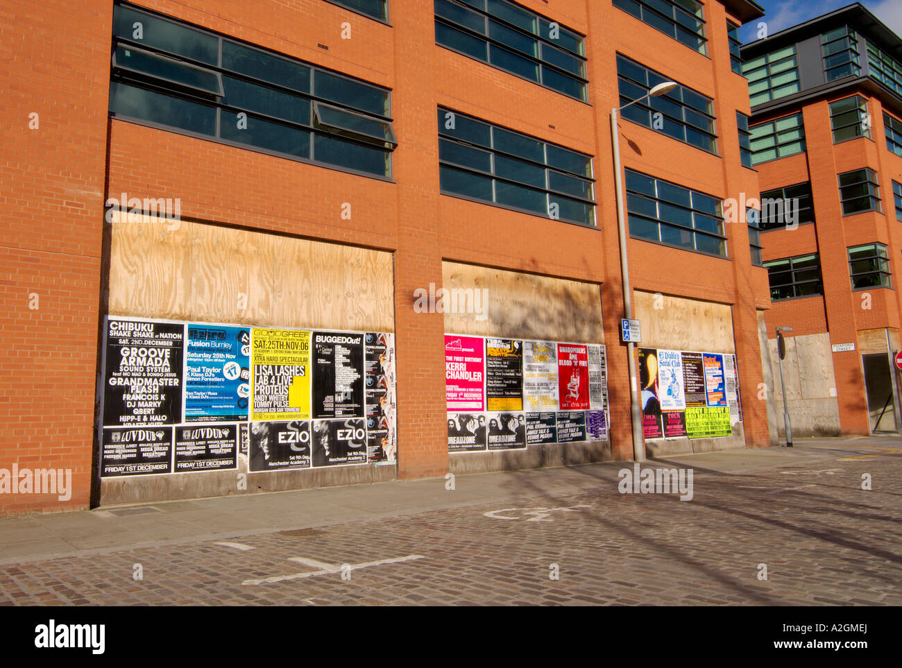 Bill posting or fly posting on modern building in Ancoats East Manchester an area being redeveloped Stock Photo