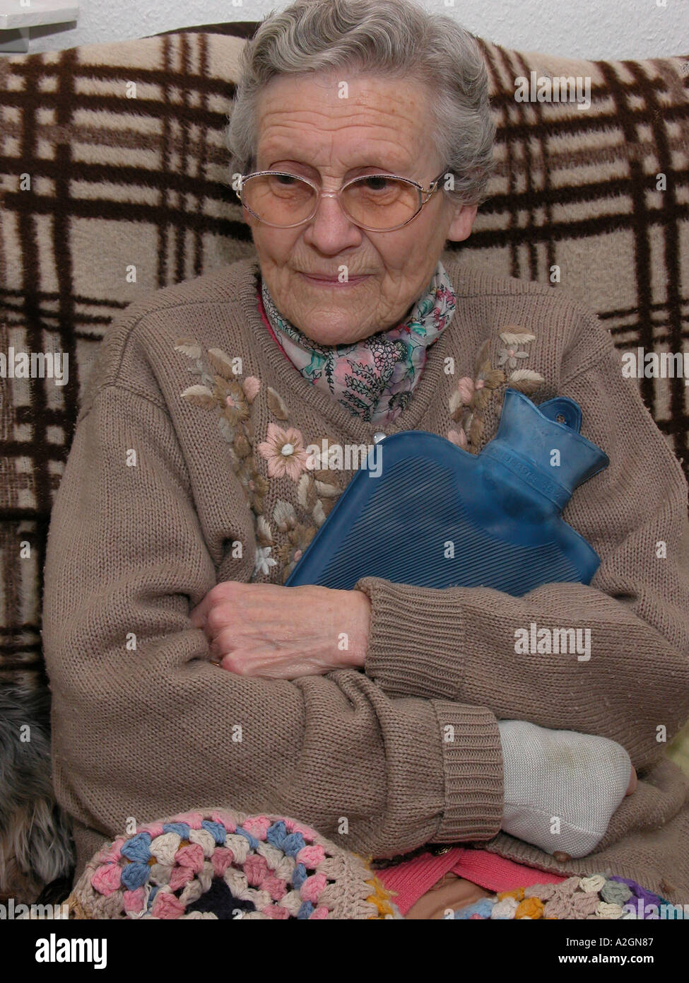 woman wearing pyjamas cuddling a hot water bottle for comfort & to keep  warm Stock Photo - Alamy