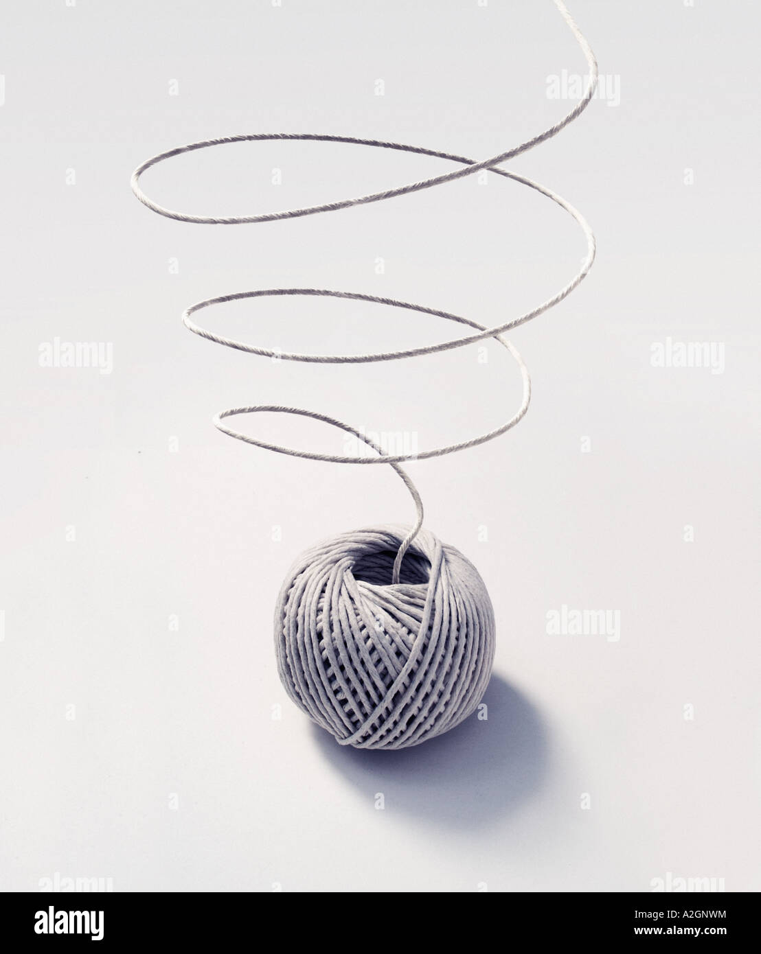 Ball of string on a white background, with loose string in a coil Stock Photo