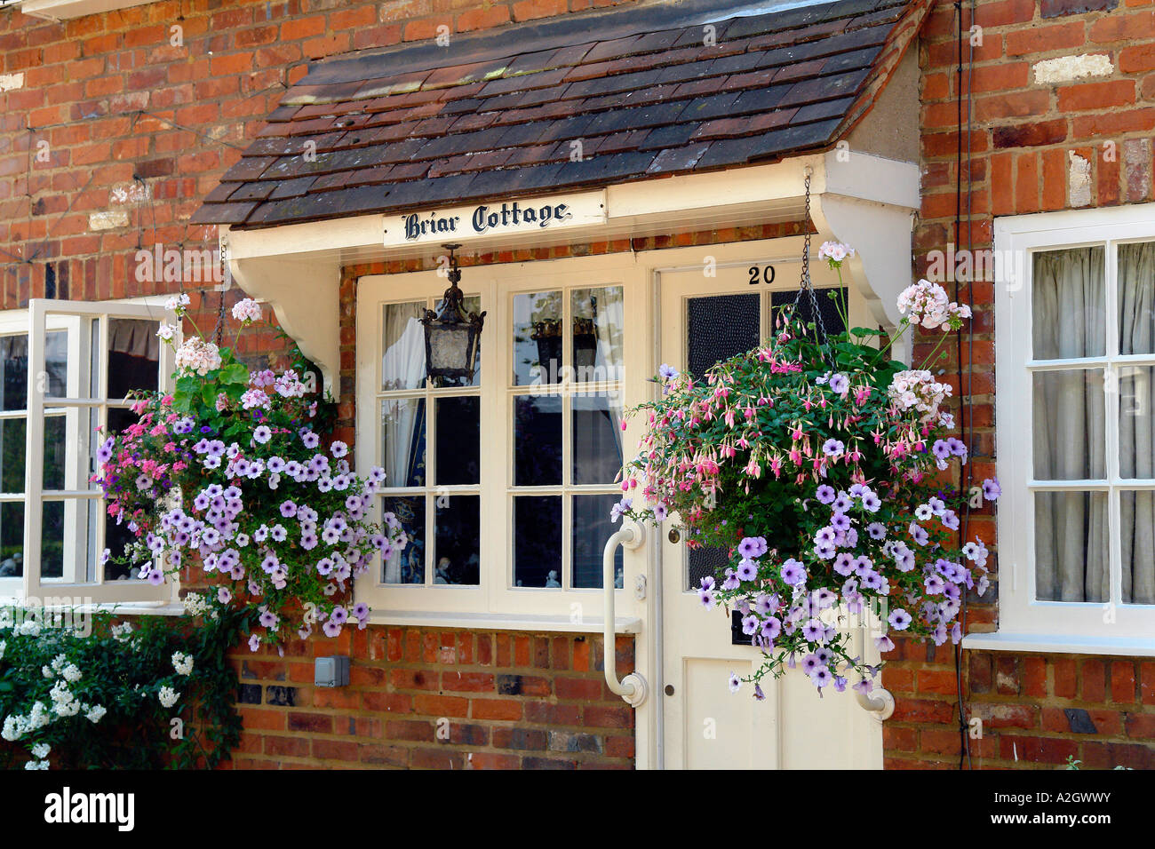English country cottage with flowering hanging baskets Stock Photo Alamy