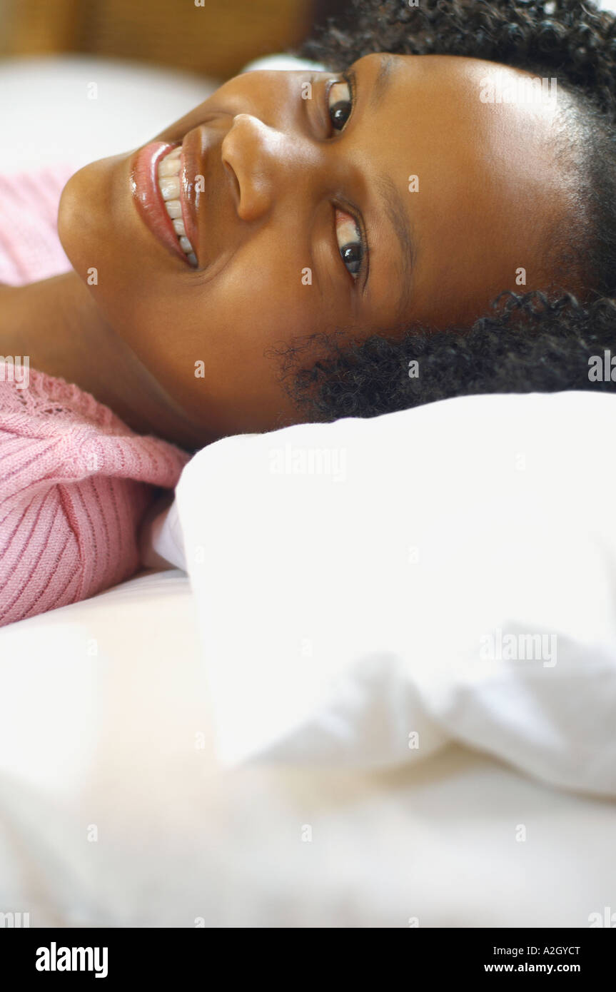 Close up of young African woman laying down and smiling Stock Photo