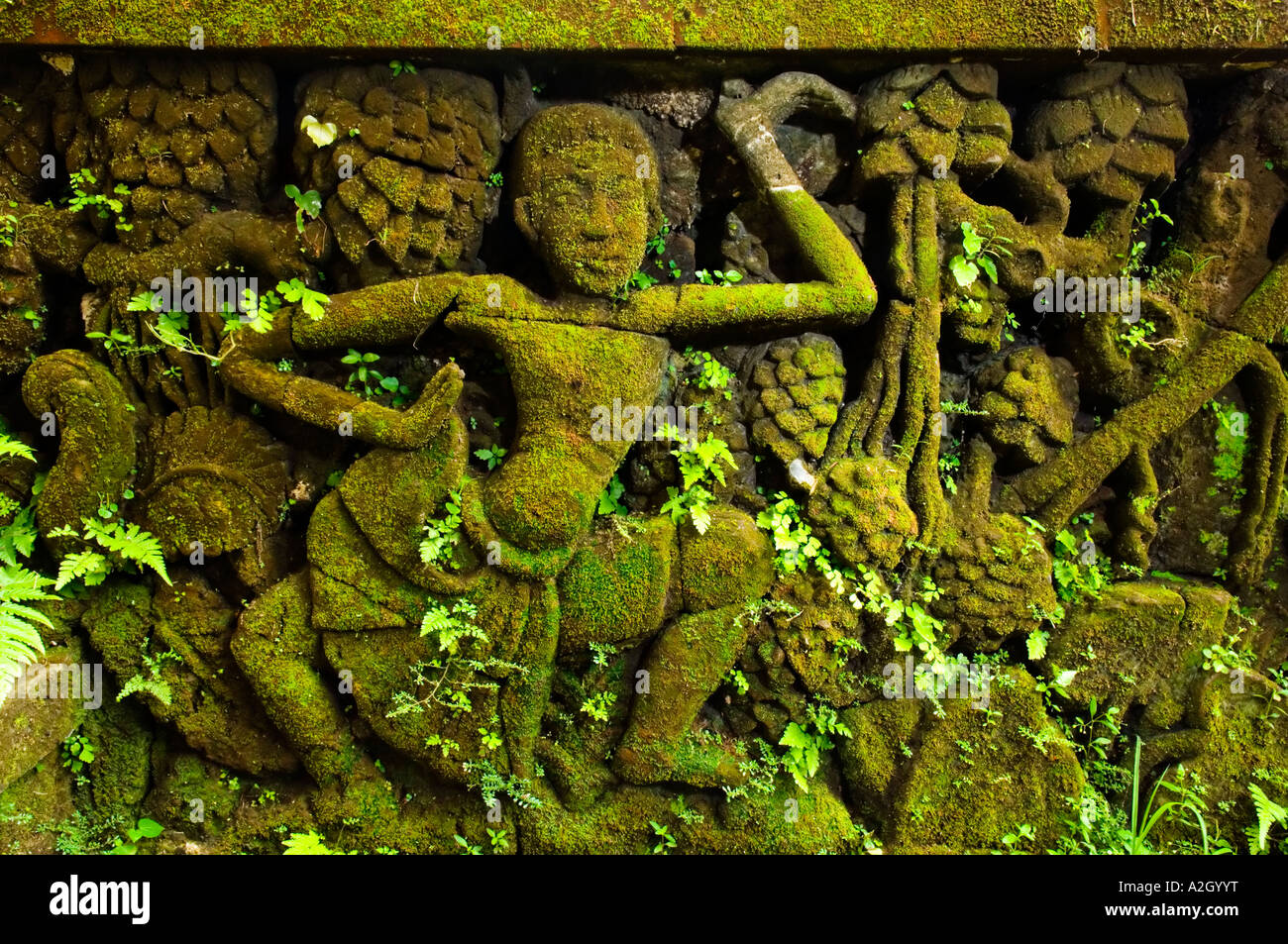 Indonesia Bali Ubud Agung Rai Museum of Art ARMA stone images covered by green moss and small plants dancer Stock Photo