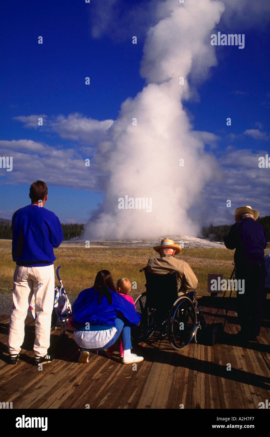 Group of people watching eruption of Old Faithful geyser Yellowstone National Park Wyoming Stock Photo