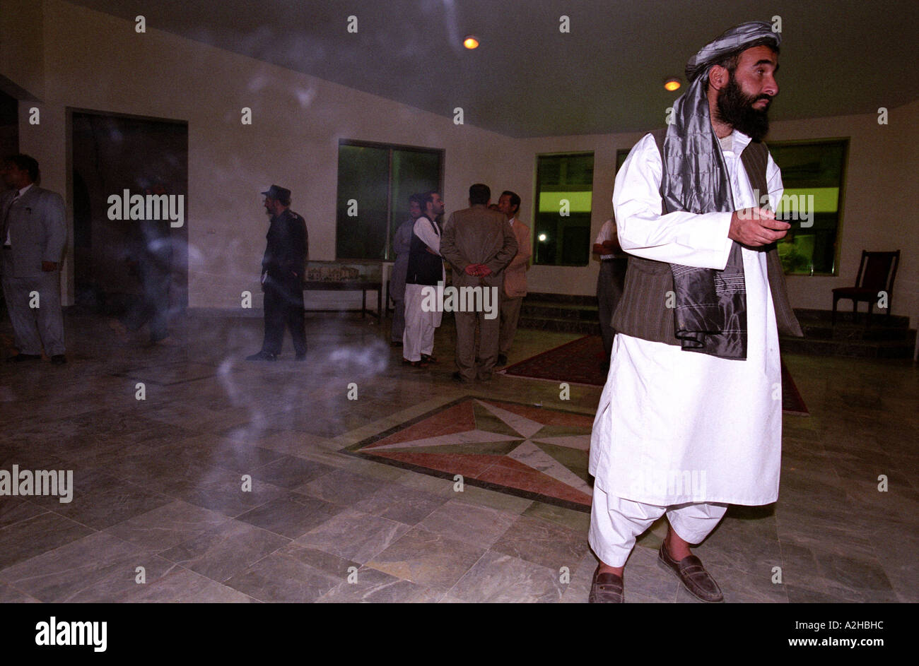 An afghan man wearing traditional dress is standing at the entrance of the Helmand Governor residence Stock Photo