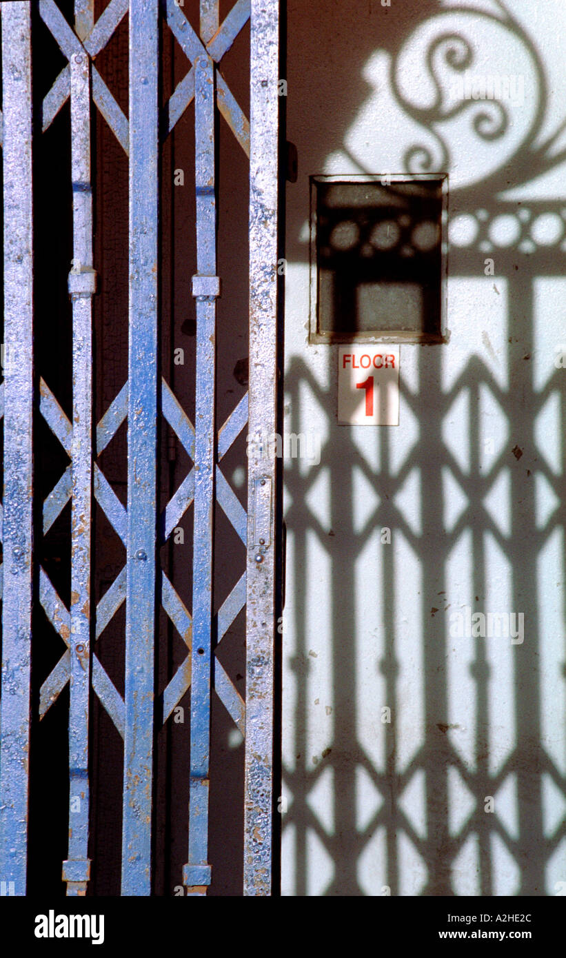 Close up of a folding iron grill and the shadow it casts on a door Stock  Photo - Alamy