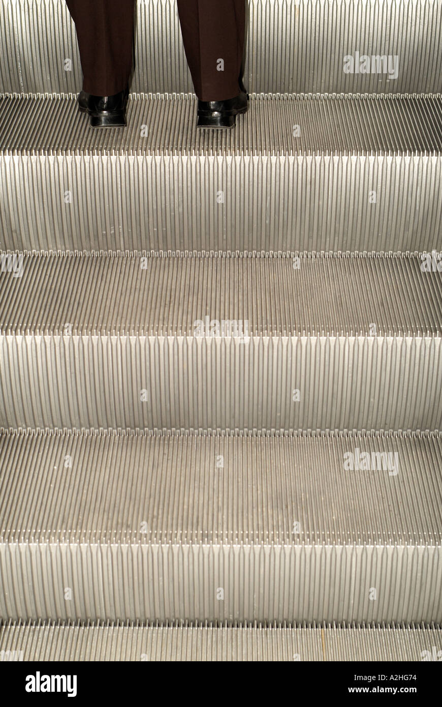 Businessman Going up an Escalator Stock Photo