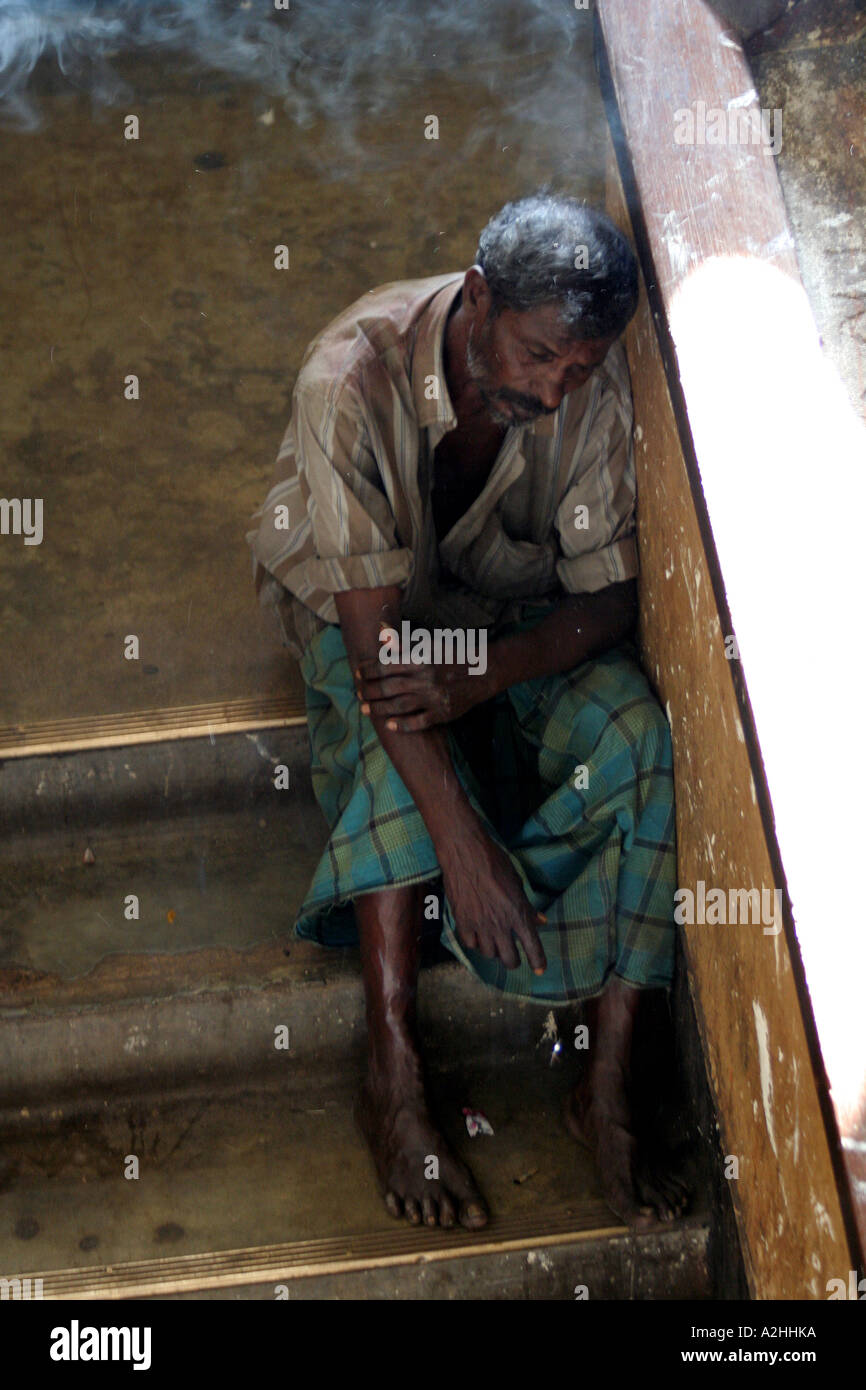 Dejected man in a stairwell at the Kandy Main Market, Kandy, Sri Lanka Stock Photo