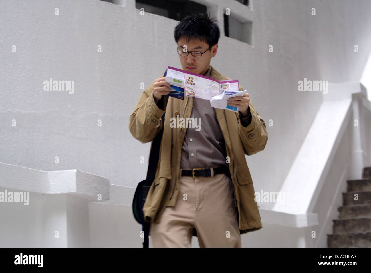 Korean American walking and reading a map while traveling in Hong Kong Stock Photo