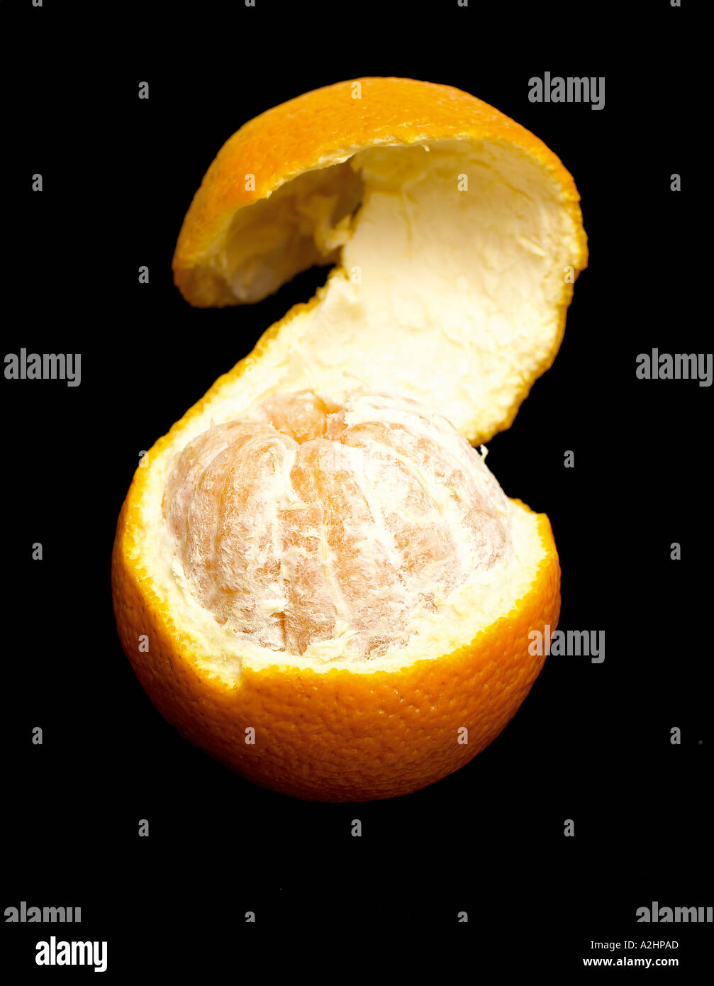 Portrait shot of orange peel coming off on black background Stock Photo