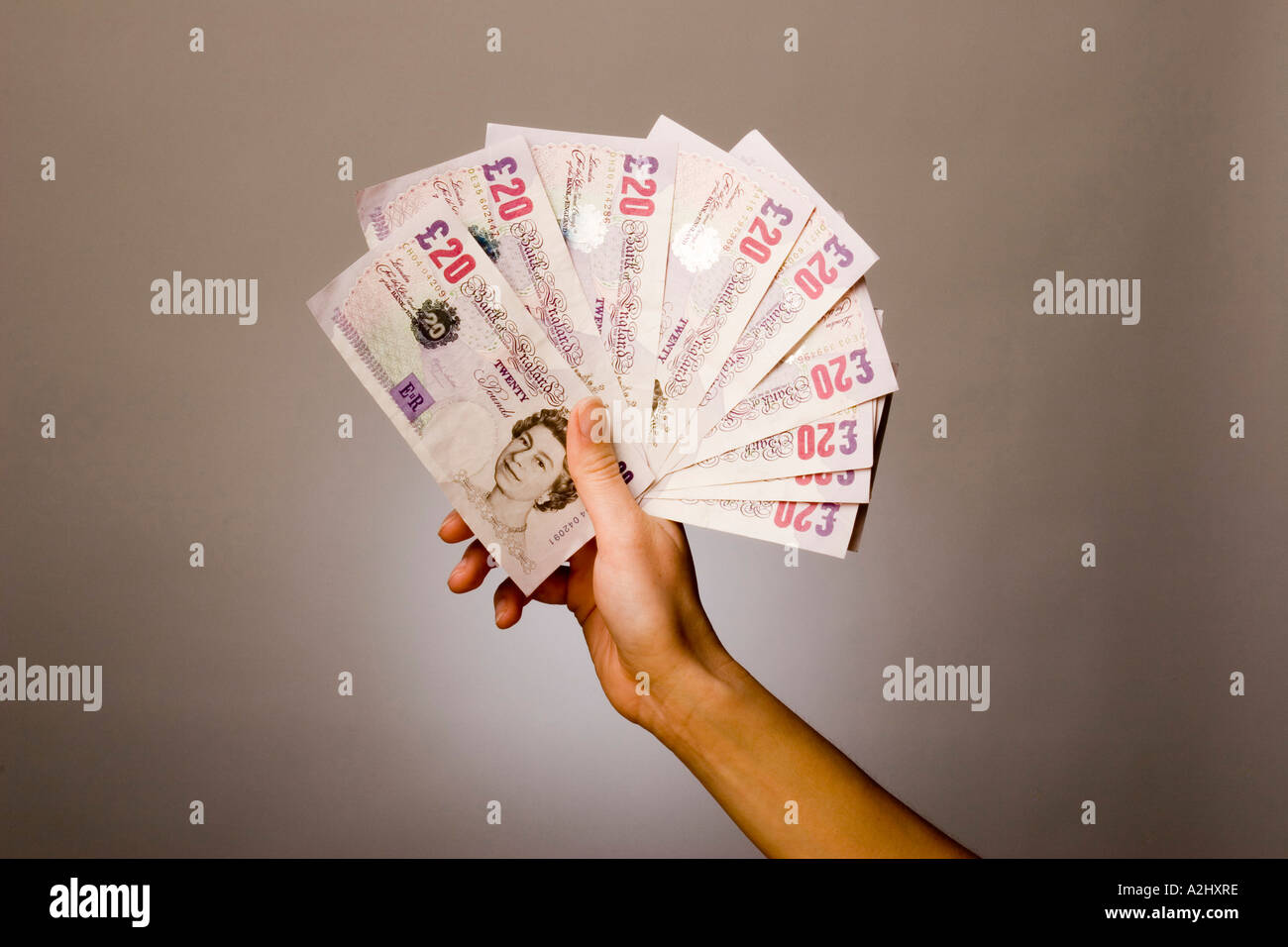 Hand holding/displaying a  fan of £20.00 notes Stock Photo