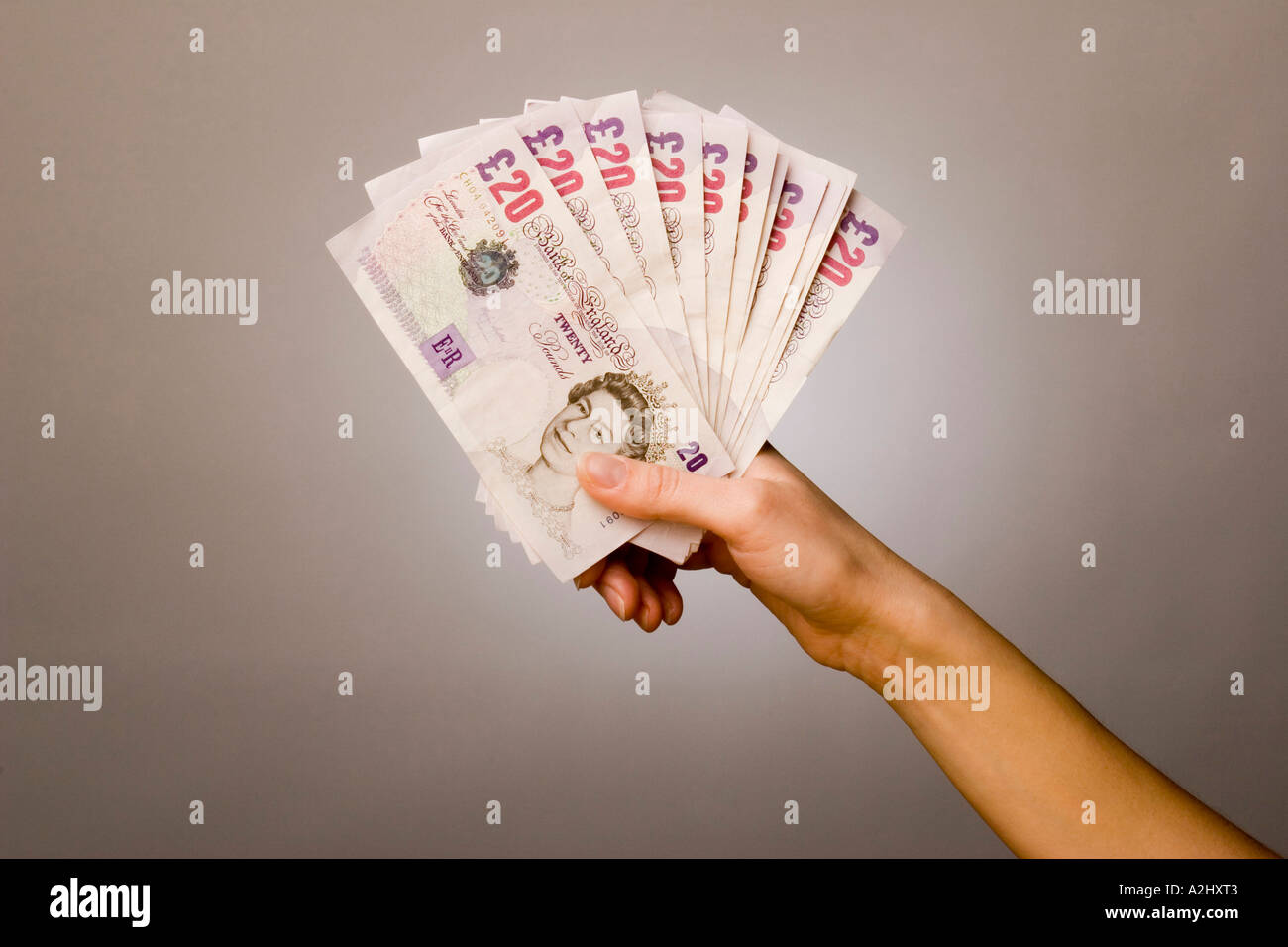 Hand holding/displaying a  fan of £20.00 notes Stock Photo