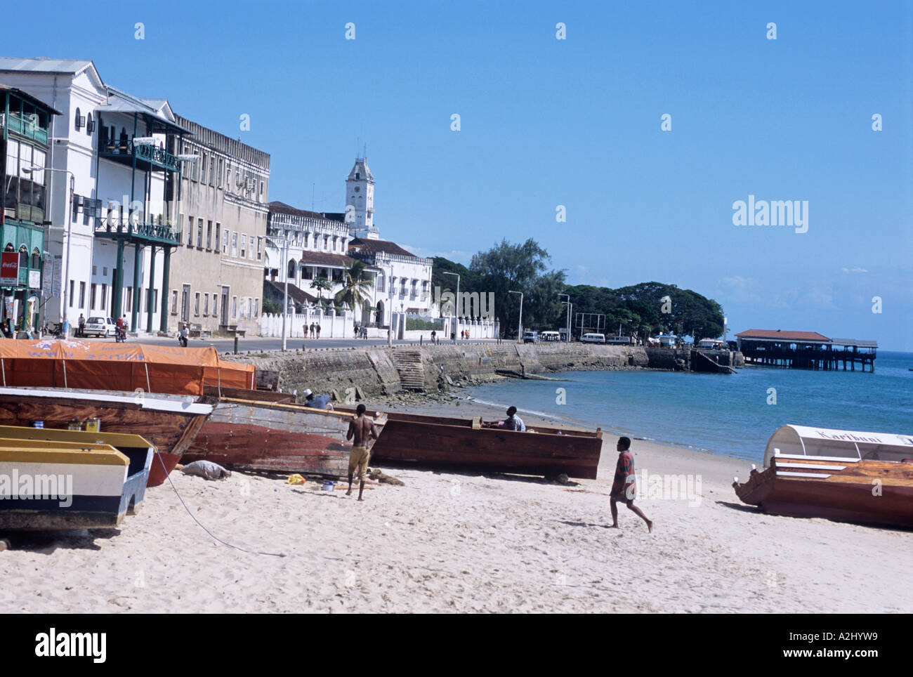 On  the Zanzibar waterfront close to Mercury's restaurant are fishing boats and, far left, the towered House of Wonders Stock Photo