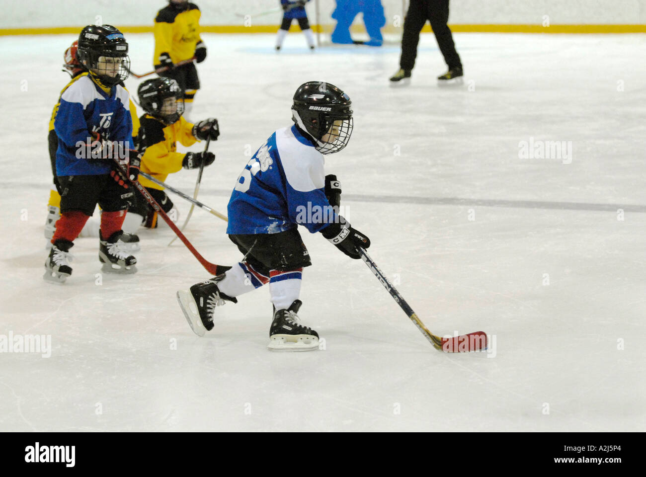 5 year old boys learn how to play the game of ice hockey Stock Photo
