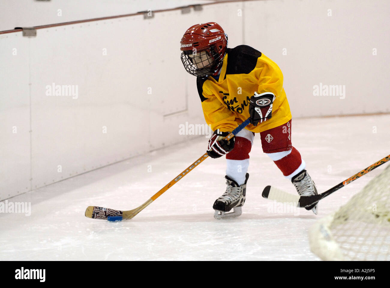 5 year old boys learn how to play the game of ice hockey Stock Photo