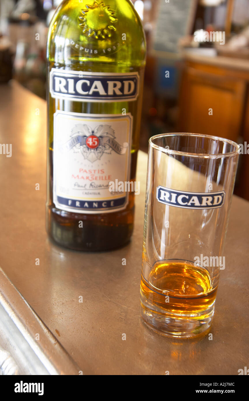 A bottle of Ricard 45 pastis and a glass on a zinc bar in a cafe