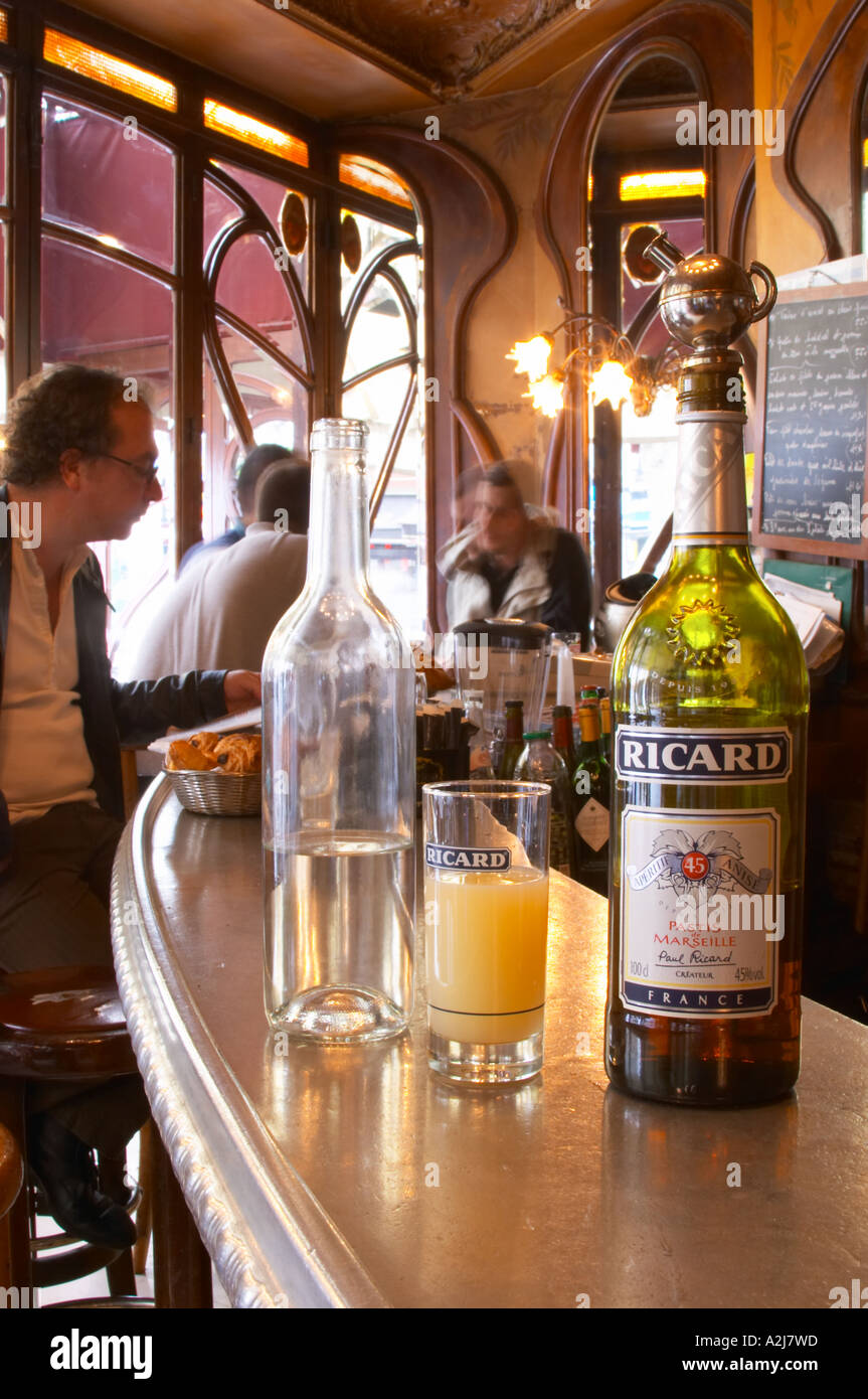 A bottle of Ricard 45 pastis and a glass and a carafe of water on a zinc  bar in a cafe bar in Paris. In the background people si Stock Photo - Alamy