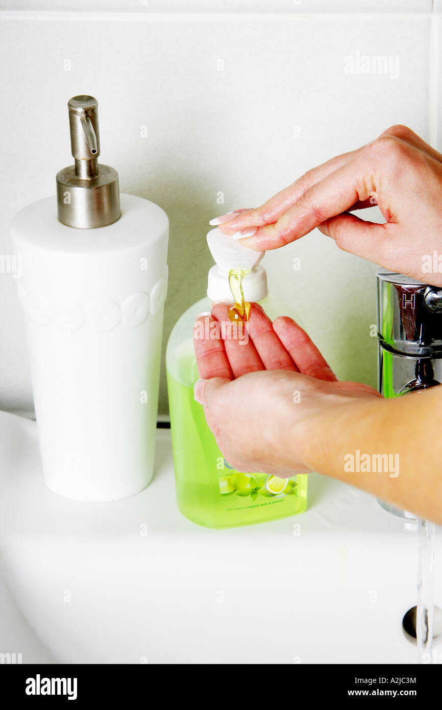 Young Woman Washing Her Hands In A Bathroom Sink With Soap And Water ...