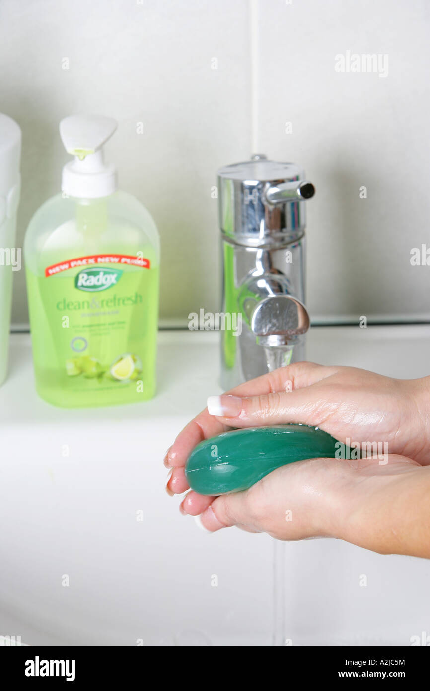 Young Woman Washing Her Hands In A Bathroom Sink With Soap And Water ...