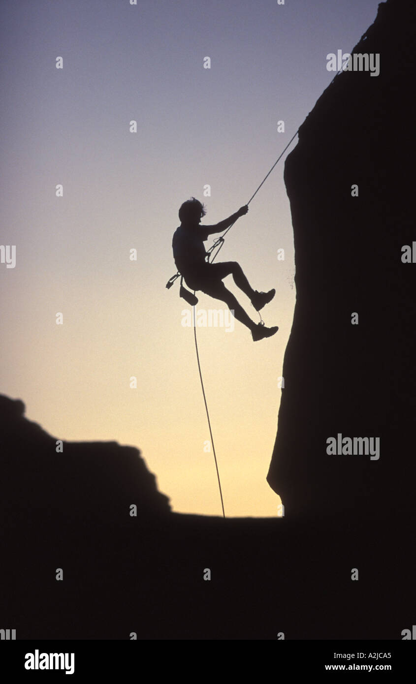 Silhouette of a mountain climber rappelling down a cliff Stock Photo Alamy