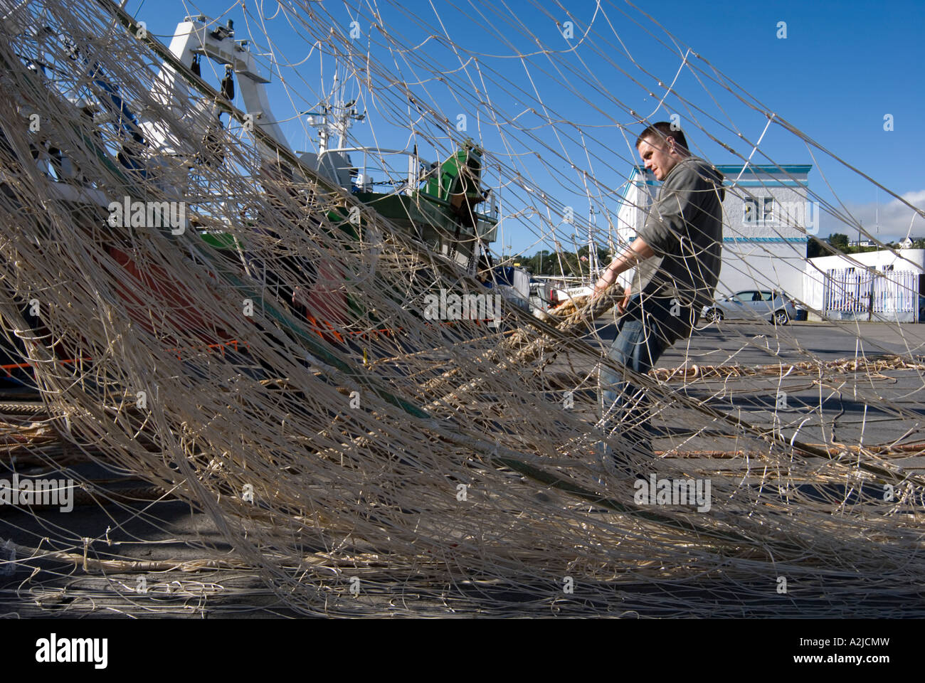 Fishermen work to untangle and repair nets Stock Photo