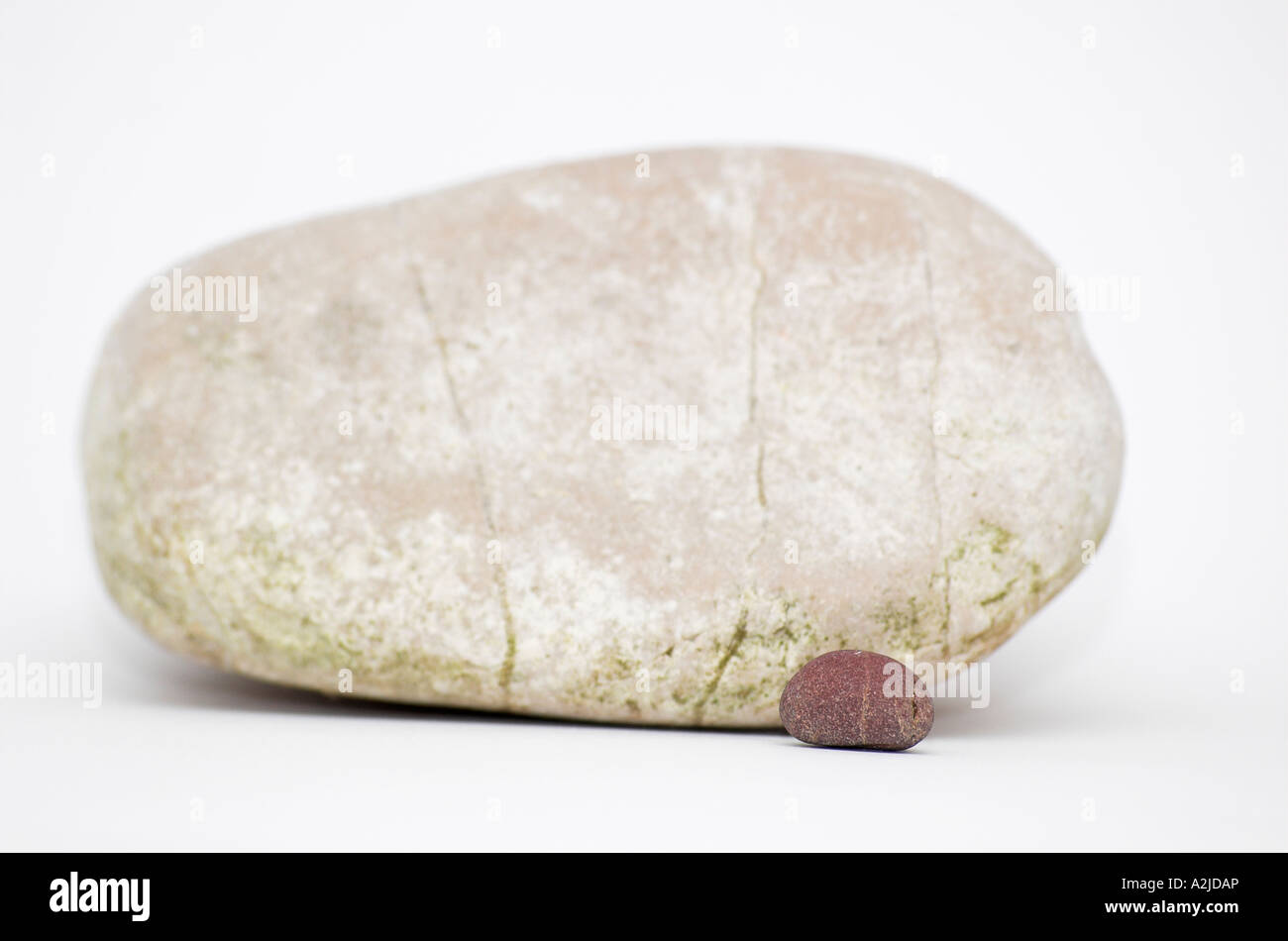 Small dark pebble by large white pebble Stock Photo