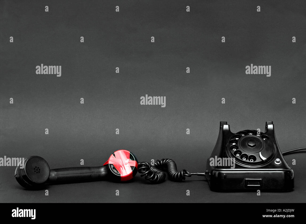 Black telephone with receiver off the hook red tape around mouthpiece