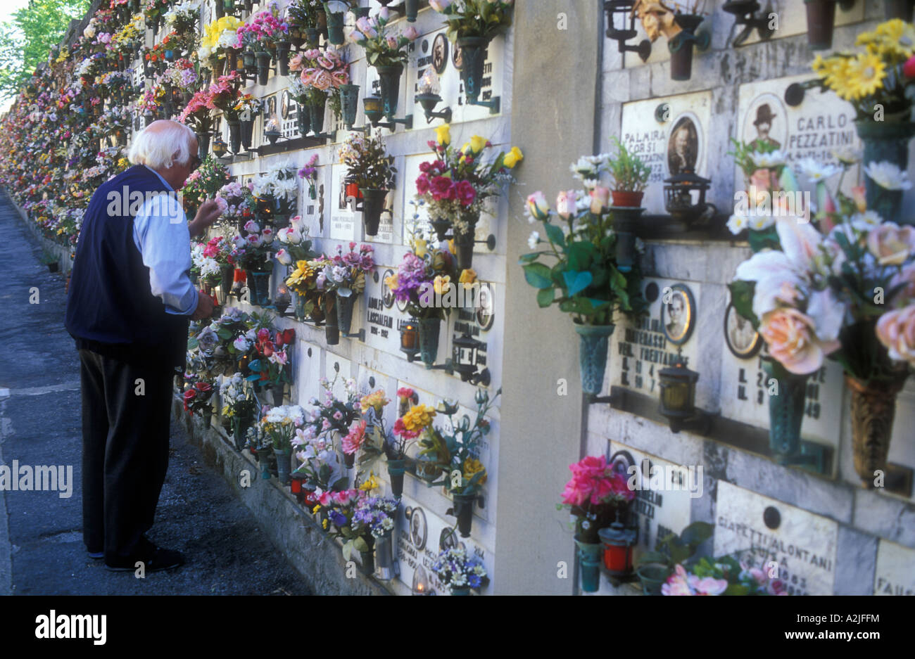 Italy Fiesole elderly man placing flowers in cemetery Stock Photo